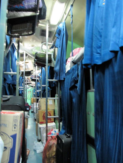 Innenansicht unseres Schlafwagens. Wie eine lange Reihe Doppelstockbetten auf beiden Seiten. In der Mitte das gestapelte Gepäck der Fahrgäste.