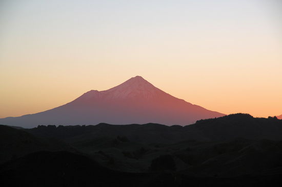 Mit der untergehenden Sonne erreichten wir den letzten Höhenzug vor Stratford (Strathmore Saddle) und hatten diesen fantastischen Ausblick auf den Mount Taranaki. Der über 2.500 Meter hohe Vulkan mit seiner perfekten Spitzkegelform dominiert als Landmarke die Westküste und ist ein sehr beeindruckender Anblick.