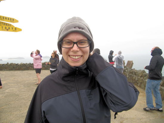 Lizzy gut eingepackt am Leuchtturm. Starker Wind, einstellige Temperaturen und Nieselregen - man beachte die Dame im Hintergrund in Shorts und Flip-Flops!