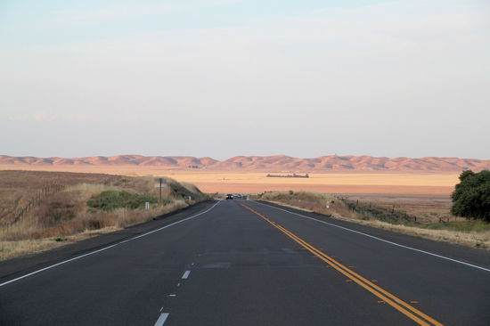 Auf dem Weg zum Kings Canyon und Sequoia Nationalpark. Eine weite trockene Ebene mit schnurrgraden Highways.