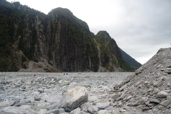 steil und senkrecht im Gletscherbett des Fox Glacier (die kleinen schwarzen Punkte sind Menschen...)