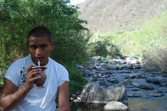 Pablo beim Mate trinken.  Im Hintergrund der Bach, in dem wir am naechsten Tag gebadet haben. In Catamarca hatte es naemlich ungefaehr 35 Grad und eine sehr hohe Luftfeuchtigkeit. Abkuehlung war also mehr als angesagt! 