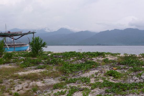 Im Hintergrund sieht man ein wolkenverhangenes Lombok und die drei Punkte im Bild...