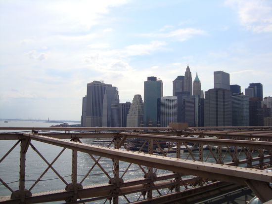 Blick von der Brooklyn Bridge auf Manhatten/ Financial District. Ganz im Hintergrund links sieht man die Freiheitsstatue.