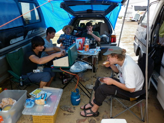 ...aber nicht ohne uns zu zwingen ein paar Planen aufzuhängen, unter denen wir unser Fressgelage beginnen konnten! Was ein Fest!
Hinten links sitzt Daniel und rechts daneben Tosh.