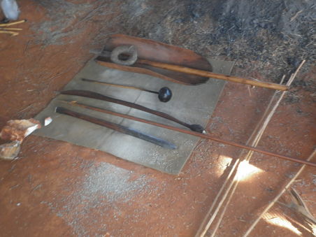 Von unten nach oben: eine Art Allzweckwerkzeug mit feuergehärteter Spitze zum graben, hauen und holzbearbeiten oder auch Stock; ein Speer; ein Speerwerfer (die Aboriginetechnik Speere zu werfen erinnert ein wenig an diese Tennisballwurfgeräte, mit denen Hundebesitzer die Bälle ganz besonders weit werfen können); ein Hammer; eine Schüssel; ein Haarreif; noch ein Stock