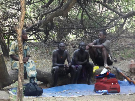 Unsere Reise geht weiter und wir verlassen das Hochland der Konso und fahren über Weyto und Jinka in den Mago N.P.  Bei der Parkverwaltung in Jinka müssen wir für den Eintritt bezahlen und bekommen zusätzlich zu unseren Begleitern, zwei weitere Begleiter  wovon einer mit einem Gewehr bewaffnet ist. Etwa 40 km nach Jinka auf einer staubigen Piste ist die Grenze des Parks erreicht. Der Mago N.P. umfasst eine Fläche von 2'162 qkm und liegt auf einer Höhe zwischen 450 m und 2'528 m. Landschaftlich finden wir dichtes Akaziengestrüpp in der Nähe des Omo vor, aber auch sanft gewellte Grassavanne und Wüste. Wir stellen unsere Zelte am Ufer des Neri-Flusses auf und unser Koch versorgt uns mit gutem Essen. Bald bekommen wir Besuch von einer Pavian-Familie und wir müssen auf unsere Zeltstadt aufpassen. Unsere Begleitmannschaft instruiert uns über den Besuch des Stammes der Mursi, welche wir morgen besuchen wollen. Die Mursi sind ein kleiner Volksstamm von weniger als 4000 Menschen. Sie sind Viehalter, Milch und Blut sind die hauptsächlich genutzten Produkte, die aber nach der Regenzeit auch Ackerbau betreiben. Das Charakteristische an den Mursi ist der ungewöhnliche Schmuck der Frauen, die sich mit Tontellern schmücken, die sie in den aufgeschnittenen Lippen tragen. Schmucknarben und Körperbemalung sind weitere Schönheitsatribute, derer sich nicht nur die Frauen bedienen, sondern auch die Männer. Die Beschneidung von Mädchen oder jungen Frauen ist nicht nur bei den Völkern am Unterlauf des Omos weit verbreitet. Generell lässt sich beobachten, dass sich in den letzten 100 Jahren für die Mursi die Lebenssituation nicht grundsätzlich verändert hat bis auf einige Handwasserpumpen und einer Polizeistation. Sie sind ein sehr kriegerisches Volk der Region und es gibt ständige Auseinandersetzungen bedingt durch Viehdiebstahl, aber auch zunehmend mit Stämmen aus den Grenzgebieten zu Nordkenia und Süd-Sudan. Sie sind mit uralten Flinten, aber immer mehr auch mit automatischen Waffen ausgestattet, die sie bei entsprechender Gelegenheit auch bedenkenlos einsetzten. Einkommensmöglichkeiten sind nicht vorhanden, deshalb müssen die Touristen für jedes Foto bezahlen. Die Honorare für Fotos sind festgelegt und indiskutabel: 3 Birr (0,20 Sfr.) für ein Porträt einer Einzelperson, 5 Birr wenn Mutter und Kind fotografiert werden. Wenn sich die Kontakte allein auf dieses Geschäft reduziert, haben wir das Gefühl als würden wir einen Zoo besuchen!