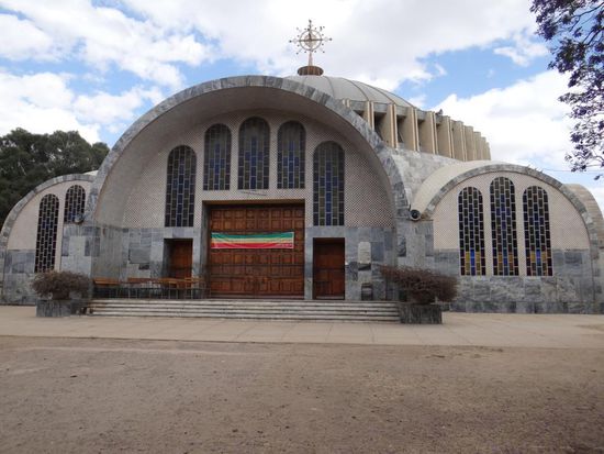 Die Kathedrale der Heiligen Maria von Zion im Zentrum der Stadt ist das älteste und wichtigste Kirchengebäude der äthiopisch-orthodoxen Kirche. Eine Kapelle hütet angeblich das grösste Heiligtum Äthiopiens, die Original-Bundeslade mit den steinernen Gesetzestafeln Moses. Laut äthiopischen Quellen aus dem 14. Jh. soll die Königin von Saba König Salomon in Jerusalem besucht haben und mit ihm Menelik gezeugt haben. Dieser soll später selbst nach Jerusalem gereist sein und die Bundeslade von dort mitgebracht haben. Ein Mönch ist noch heute mit der Bewachung der Bundeslade als lebenslangem Amt beauftragt. Er gibt diese Aufgabe kurz vor seinem Tod an einen Nachfolger weiter. Frauen dürfen die Kirche nicht betreten. Kaiser Haile Selassie baute 1950 eine neue Kirche direkt daneben, die für beide Geschlechter geöffnet ist. Zurzeit wird ein neues Gebäude zur Aufbewahrung der Bundeslade gebaut. Während unserem Rundgang konnten wir sogar den Patriarchen auf der Baustelle fotografieren. Wenn das nicht ein glücklicher Zufall ist!
Erst im Mai 2008 wurden in Axum die Überreste eines Palastes gefunden, der angeblich der Königin von Saba gehört haben soll.