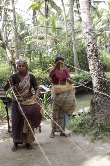 Die Frauen zeigen wie sie Schnüre drehen.