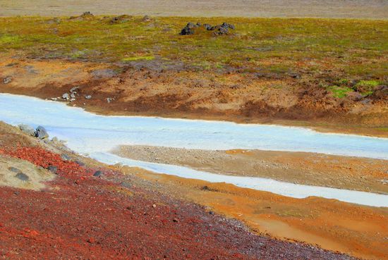 Bach am Weg zur Krafla, kristallklares Wasser mit weißlichen Ablagerungen im Bachbett