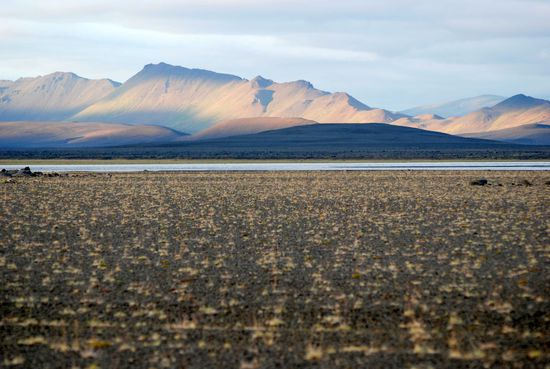 Gebirgskette auf der anderen Seite des Flusses im Licht der untergehenden Sonne...