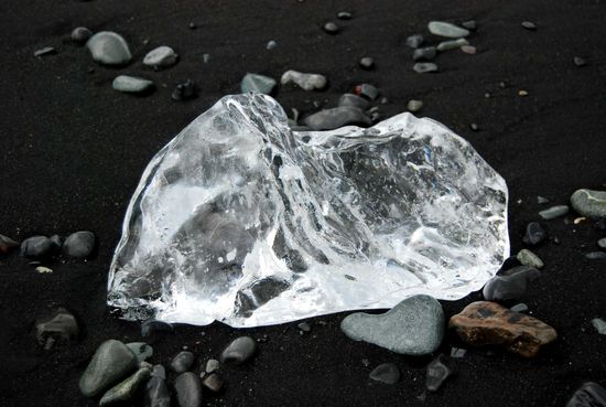 Eiskunst auf schwarzem Sand