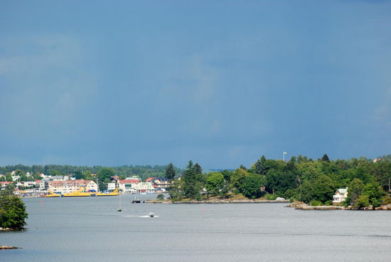 Blick auf Vaxholm, hinter dem Wald ist die Flagge auf der Festung zu sehen
