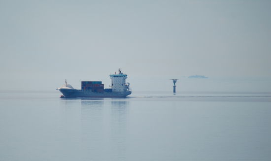 Märketskallen mit Containerschiff und am Horizont Eckerö-Linjen