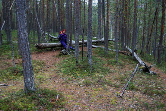 Christa erholt sich etwas auf einem Baumstamm, Wandern in Gummistiefeln ist sehr anstrengend