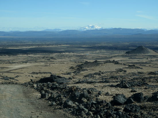 die Straße führte hinunter in die helle Bimswüste, am Horizont unser Ziel von morgen, Snæfell, der höchste Berg Íslands außerhalb der Gletscher