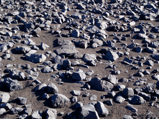 Steine auf der schwarzen Sandfläche