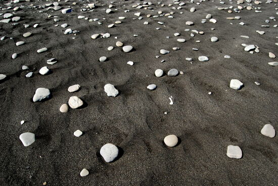 der schwarze Strand mit grauen Kieseln