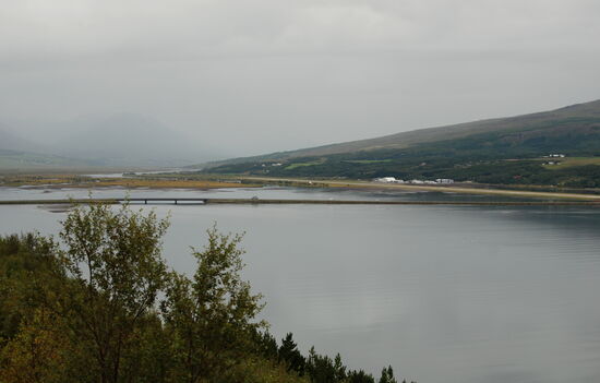 auf dem Flugplatz rechts, die N 1 führt auf dem Damm mit der Brücke durch den Fjord