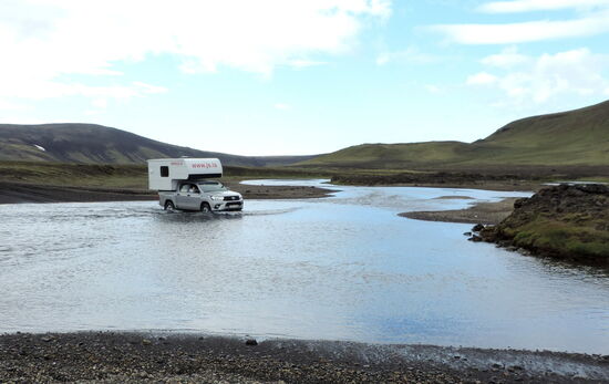 Toyota Hilux mit Campingkabine bei der Flußdurchfahrt