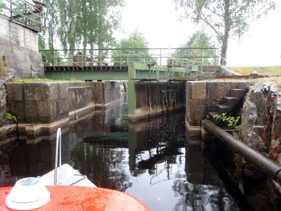 das Schleusentor öffnete sich, darüber die Brücke, die unseren Regenschirm knickte