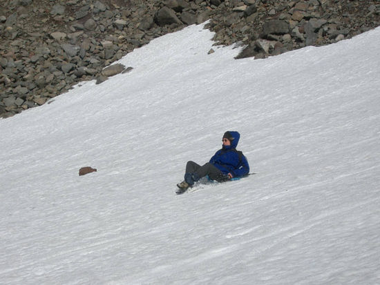 Eva rutscht das Scheefeld mit Hilfe eines Müllsacks hinunter