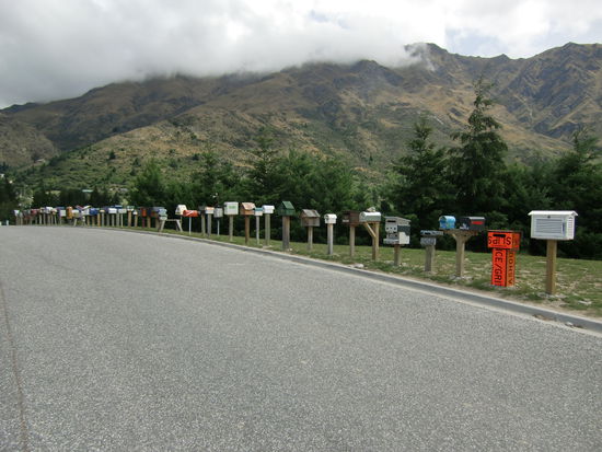 In einem kleinen Nest in der Naehe von Queenstown sind die Briefkaesten aller Einwohner an der Strasse aufgereiht. Einige haben lustige Formen: ein altes Bierfass, einer sieht aus wie ein Fisch, ein anderer wie ein Boot.