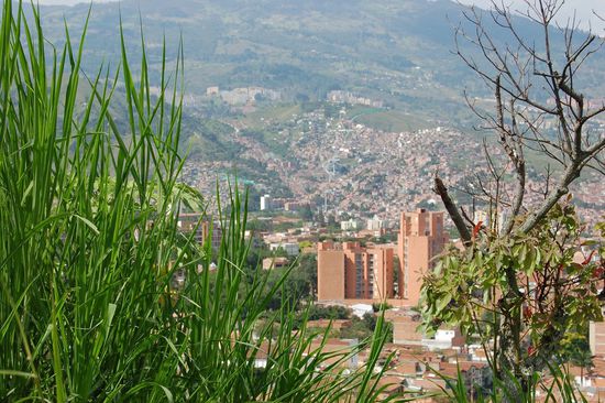 Ziemlich genau in der Mitte des Bildes fährt die Metrocable (Seilbahn) den Hügel hinauf (siehe auch "Medellin von oben")