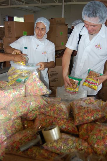 25 Stück der kleinen Granolapackung in einen Sack - Stefan hilft beim Verpacken der fertigen Ware.