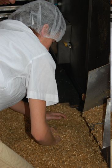 Mimi verteilt das rohe Granola auf den Backblechen.