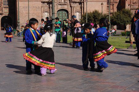 Kinder tanzen auf dem Hauptplatz traditionelle Tänze