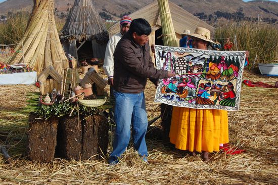Cesar erklärt uns anhand eines gewebten Bildes die Traditionen der Uros. Diese haben sich vor einigen hundert Jahren auf der Flucht vor den Inkas erfolgreich aufs Wasser zurückgezogen.