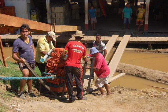 Die Jungs zerren noch über eine Stunde lang einen Ersatzmotor aufs Schiff, sicher mehrere Tonnen über diese zwei Holzbalken. 