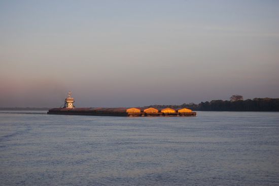Ein von der Morgensonne beleuchteter Frachter fährt hinter uns her.