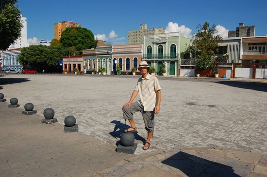 Ein Kolonialherr mit Schlapphut und Hemdkragen offen.