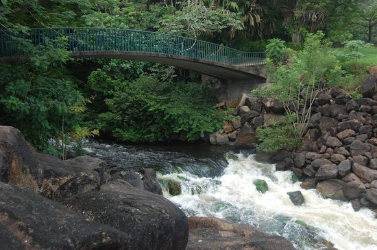 Reißendes Wasser mit romantischer Brücke im Naturpark "Parque de la llovizna"