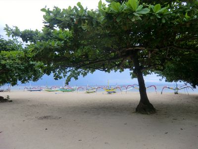 Im Hintergrund stehen traditionelle indonesische Boote