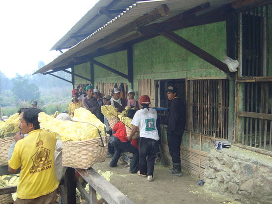 Beim Wiegen des Schwefels. Hier bekommen die Männer den Lohn für ihre harte Arbeit ausbezahlt