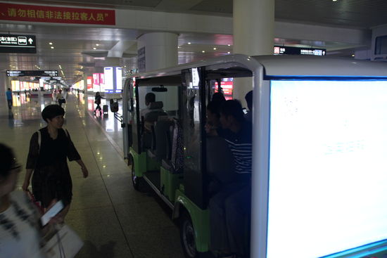 Bahnhof Shanghai. Die neuen Bahnhöfe im Schnellzugnetz sind zweisprachig und so groß, dass kleine "Busse" darin herumfahren.