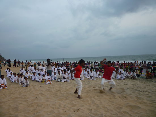 Eine Karateschule hat sich zum Training am Strand eingefunden.