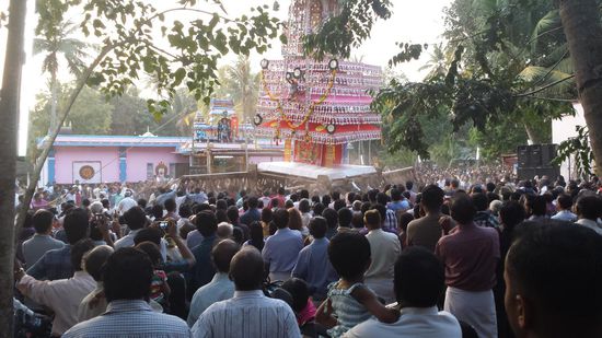 Dieser hohe Turm wird auf Stämmen von der Menge um den Tempel getragen.