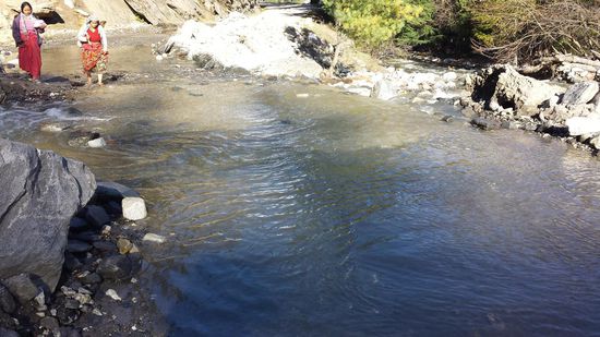 Von den Bergen fließt das Schmelzwasser über die Straße. Da hilft nur Schuhe ausziehen.