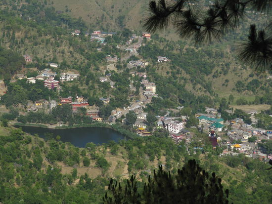 Rewalsar mit dem heiligen See. Rechts unten im Bild sieht man auch den dunkelroten Umhang der überdimensionalen Padmasanbhavastatue, der über einer Gompa thront.