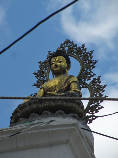 Buddha auf einer Säule vor einer Stompa (buddhistisches Gebäude) in Tansen.