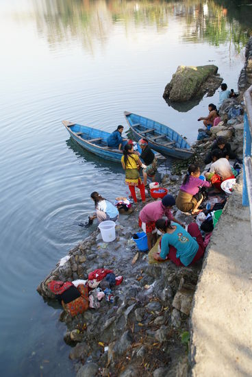 Frauen waschen ihre Wäsche am See