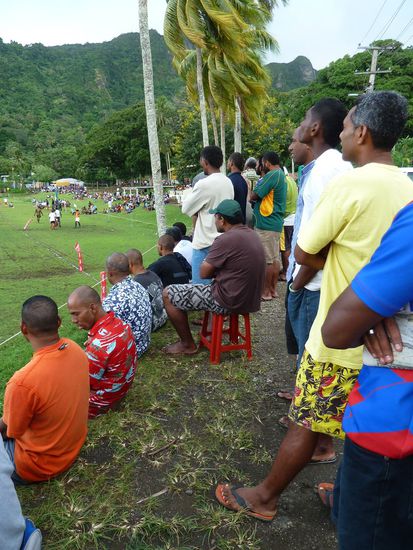 Da die Tribüne sehr klein ist, umzingeln viele Schaulustige von allen Seiten das Feld und machen sichs auch mal auf der Steinmauer gemütlich.