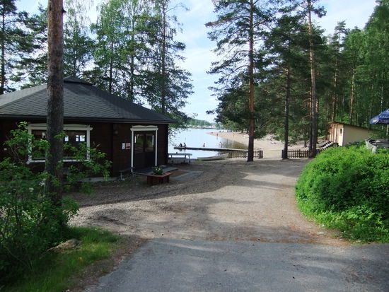 Strand mit Strandhütte links. Rechts der Sonnenschirm gehört zu einem Kioski.
