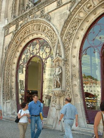 Der Bahnhof Rossio, erbaut im neo-manuelinischen Stil, ist ein großartiges Bauwerk, das zwischen den Plätzen 'Rossio' und 'dos Restauradores' liegt. Die acht Türen wurden in der Gestaltung den neun palastartigen Fenstern und der unglaublich reich verzierten Turmuhr oben auf der Fassade angepasst.
Das besondere am Bahnhof Rossio ist, dass die Gleise ca. 30 m über dem Haupteingang liegen.