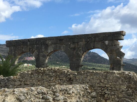 Das kleine bunte Gebäude, das durch den linken  Torbogen zu erkennen ist, ist eine Grundschule. Schulen  sind in Marokko immer bunt und liegen etwas außerhalb der jeweiligen Orte