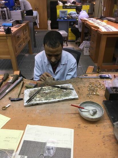 Goldschmied, auf den Zetteln vor ihm sollen sich allesamt Kundenbestellungen aus Reisegruppen befinden...